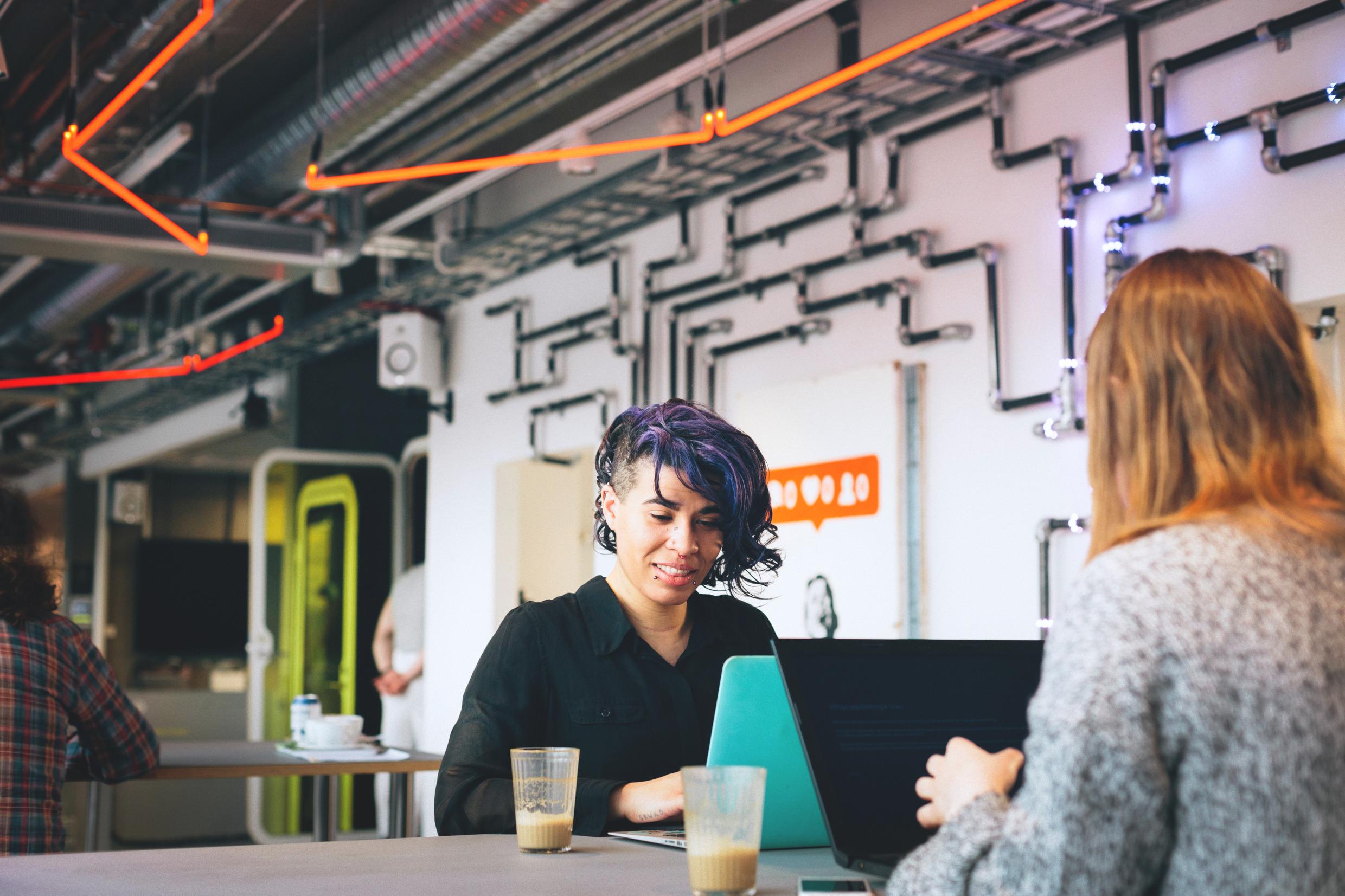 People collaborating in a vibrant coworking space in Stockholm, featuring modern industrial design and innovative decor
