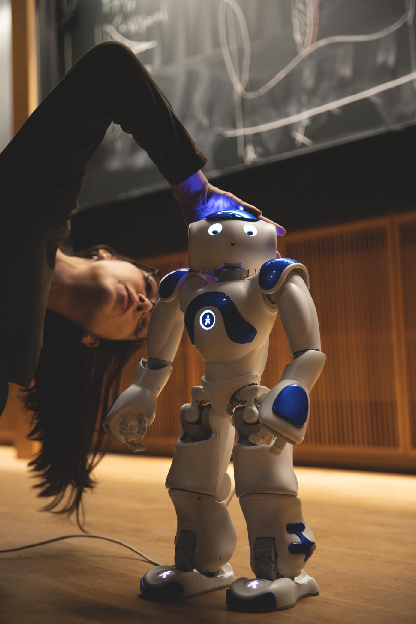 Researcher interacting with a humanoid robot in a laboratory setting in Stockholm, symbolizing innovation in robotics and AI.