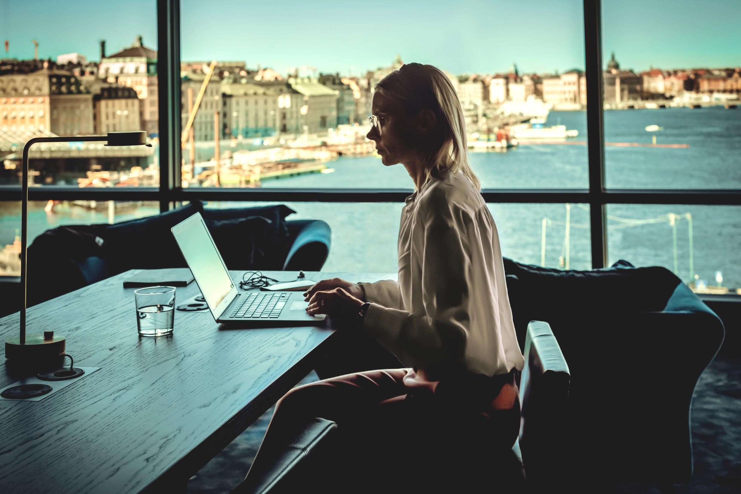 Woman working in Stockholm with panoramic view over the Old Town and the city