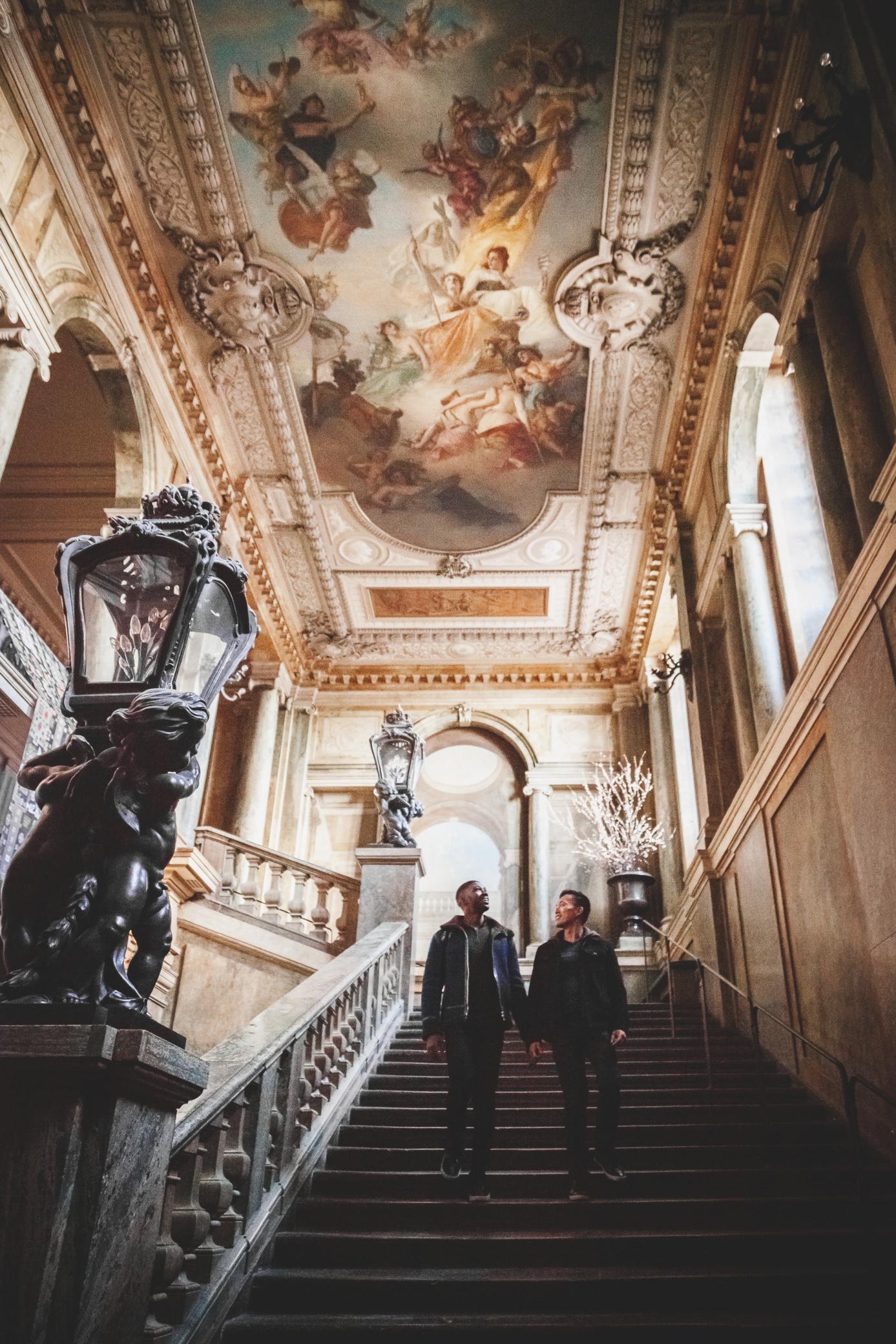 Two men walking down a staircase inside the Royal Palace in Stockholm.